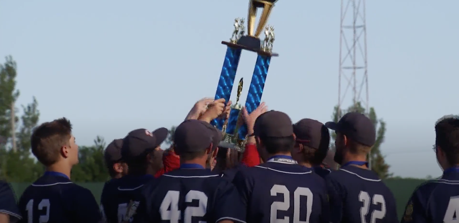 High school boys baseball team holding up a trophy