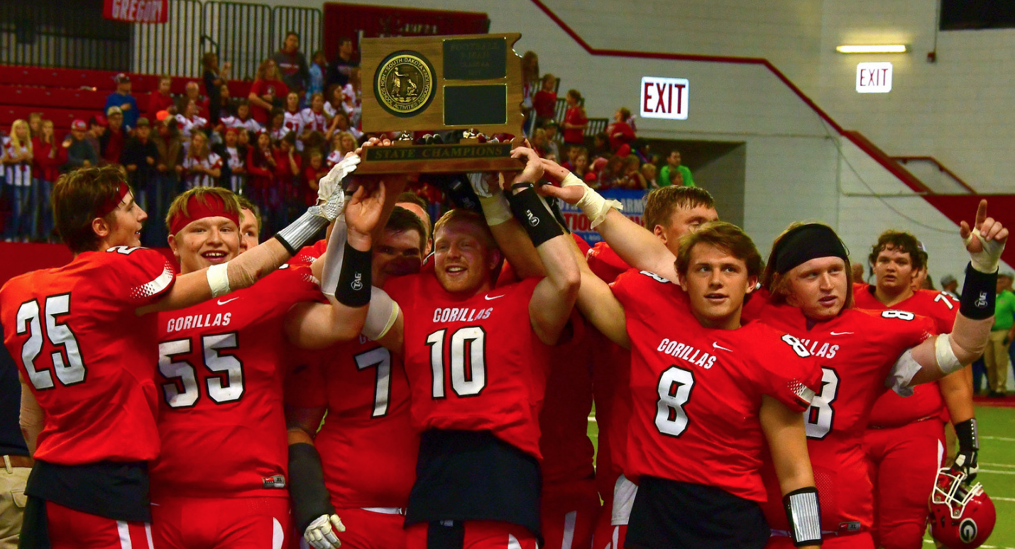 Gregory football players holding state champion trophy 