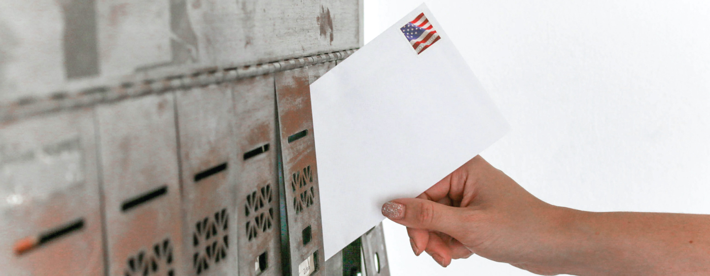 Person places an envelope in a mail box