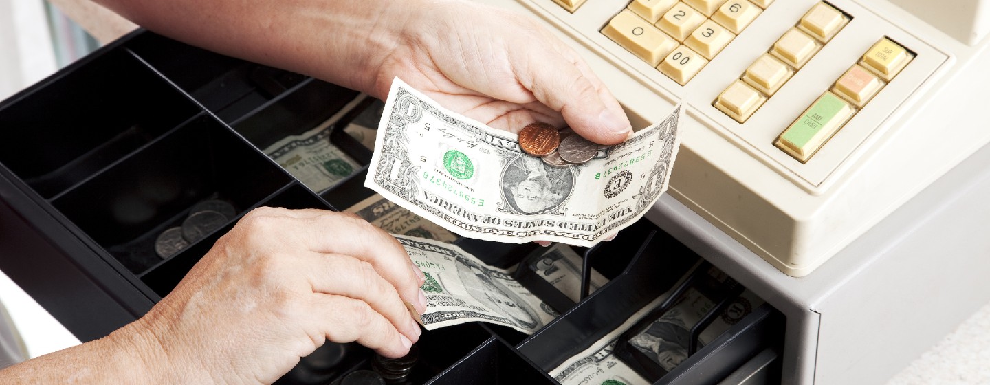 Person handles cash from a cash register