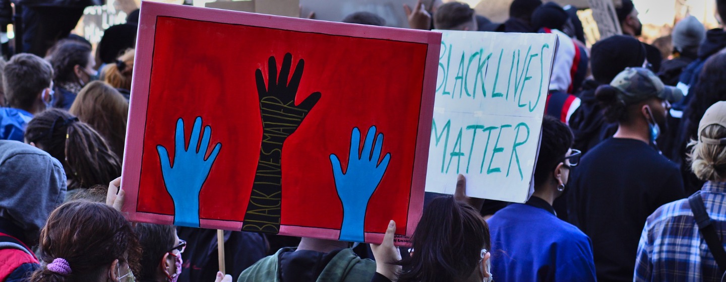 Black Lives Matter signs hoisted in a crowd
